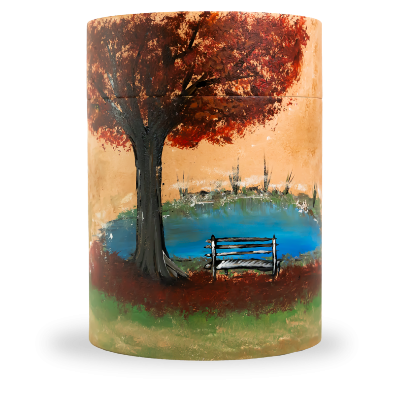 Die Bambusurne hat eine zylindrische Form und zeigt ein gemaltes Motiv mit einem Baum, einer Bank und einem Teich in warmen Farben.