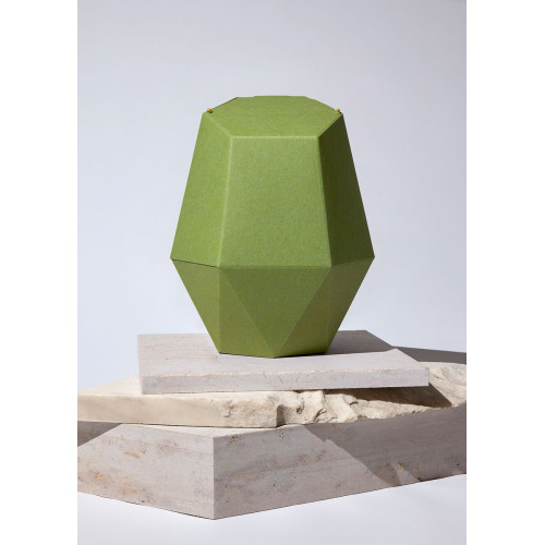 Die Kinderurne Frühling aus grünem Recycling-Karton hat eine geometrische, facettierte Form und steht auf einer neutralen, hellen Unterlage.